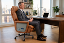 Tall executive seated comfortably in a leather office chair with full thigh support, feet flat on the floor, and proper backrest alignment.