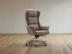 Brown office chair on wheels in a room with wooden flooring and a beige wall.