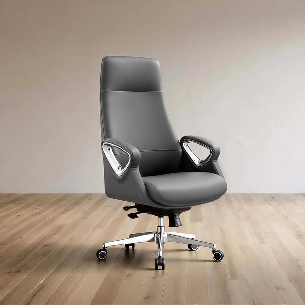 A modern gray leather office chair with a high back, curved armrests, and a chrome five-star base with casters, set against a minimalist beige wall and light wood floor.