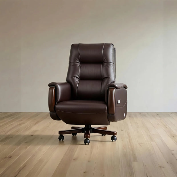 A dark brown leather office chair with a high back, padded armrests, and a five-star wheeled base, shown in a minimalist room with light wood flooring and a beige wall.