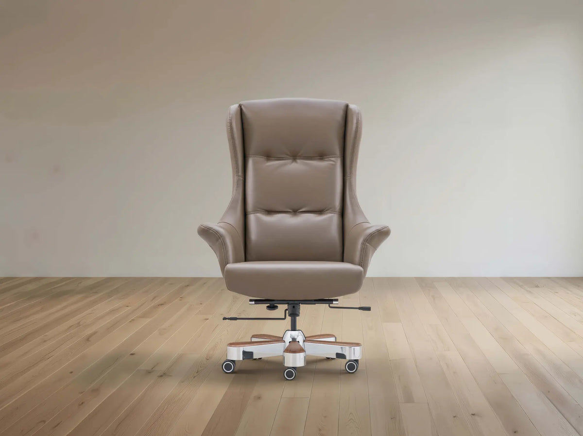 A beige leather high-back wingback office chair with a white and chrome wheeled base, set against a minimalist beige wall and light wood floor.