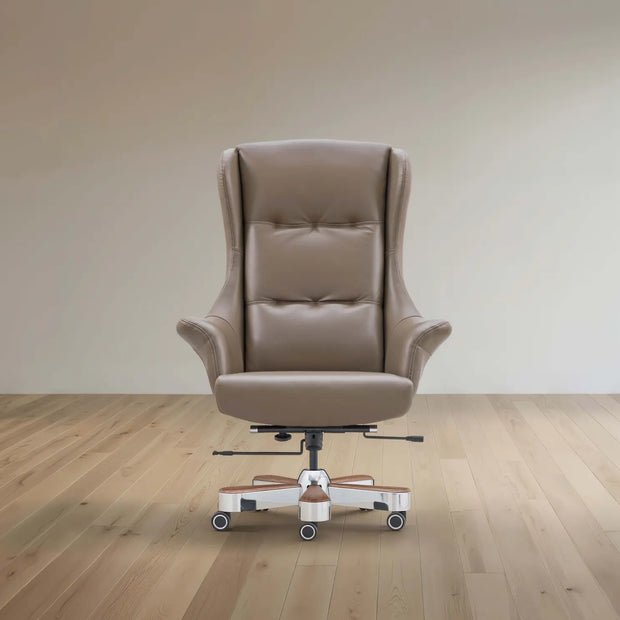 A beige leather high-back wingback office chair with a white and chrome wheeled base, set against a minimalist beige wall and light wood floor.