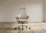 A modern high-back office chair with cream leather upholstery, brown leather arm accents, and a chrome five-star base, set against a minimalist beige wall and light wood floor.