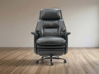 A dark gray leather office chair with a high back, padded armrests, and a chrome five-star rolling base, set against a minimalist beige wall and light wood floor.
