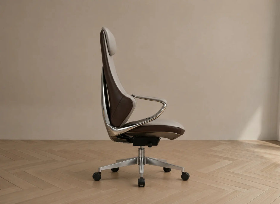 A modern high-back office chair with a brown and white upholstered seat and back, supported by a chrome metal frame and five-star wheeled base, set against a minimalist beige wall and light wood herringbone floor.