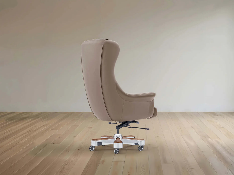 A modern high-back upholstered office chair in a warm taupe-beige color, shown from the side on a light wood floor against a neutral beige wall.