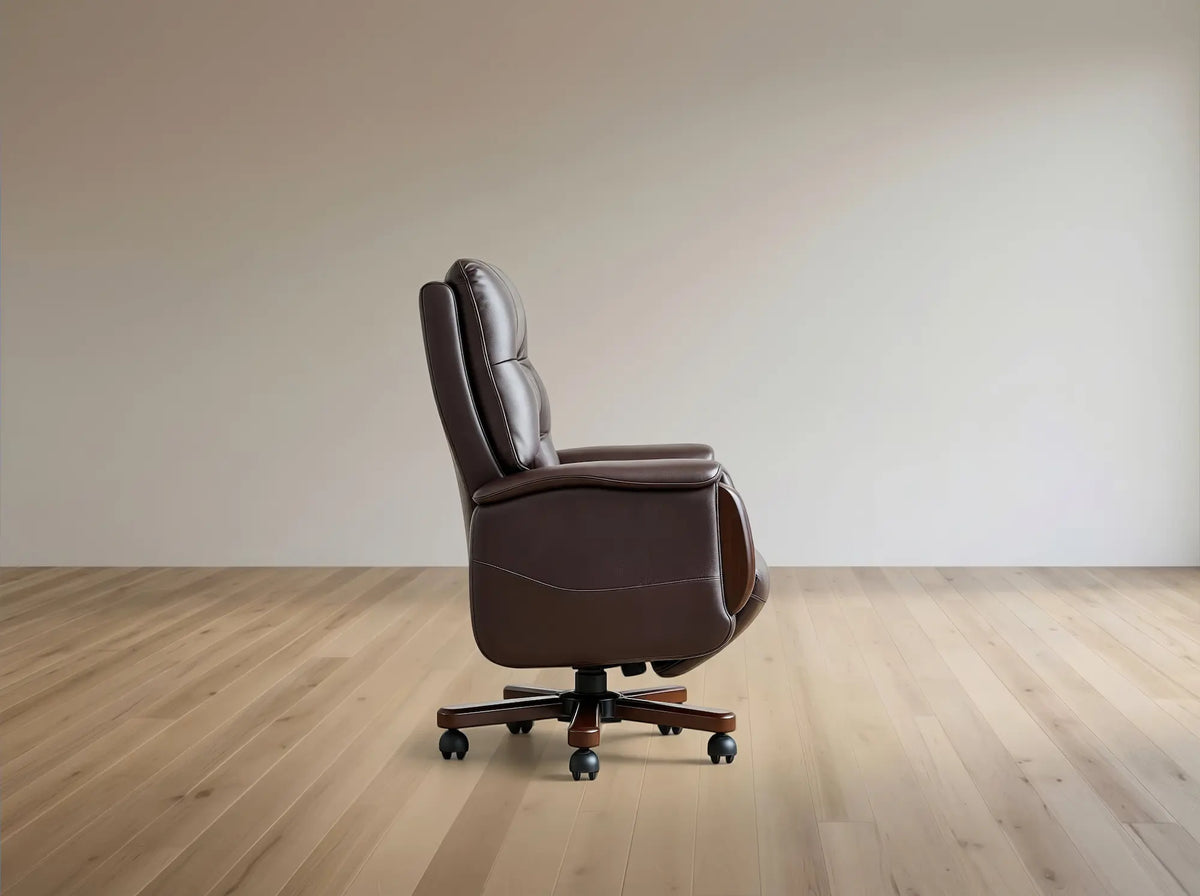 A dark brown leather office chair with a high back and five-star wheeled base, shown in profile on a light wood floor against a neutral beige wall.