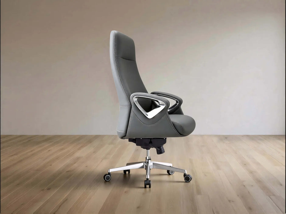A modern gray office chair with a high back, textured fabric upholstery, and a silver five-star wheeled base, set against a minimalist beige wall and light wood floor.