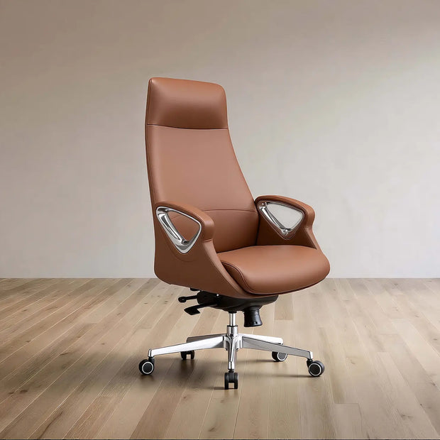 A brown leather high-back office chair with silver armrest supports and a chrome five-star wheeled base, set against a minimalist beige wall and light wood floor.