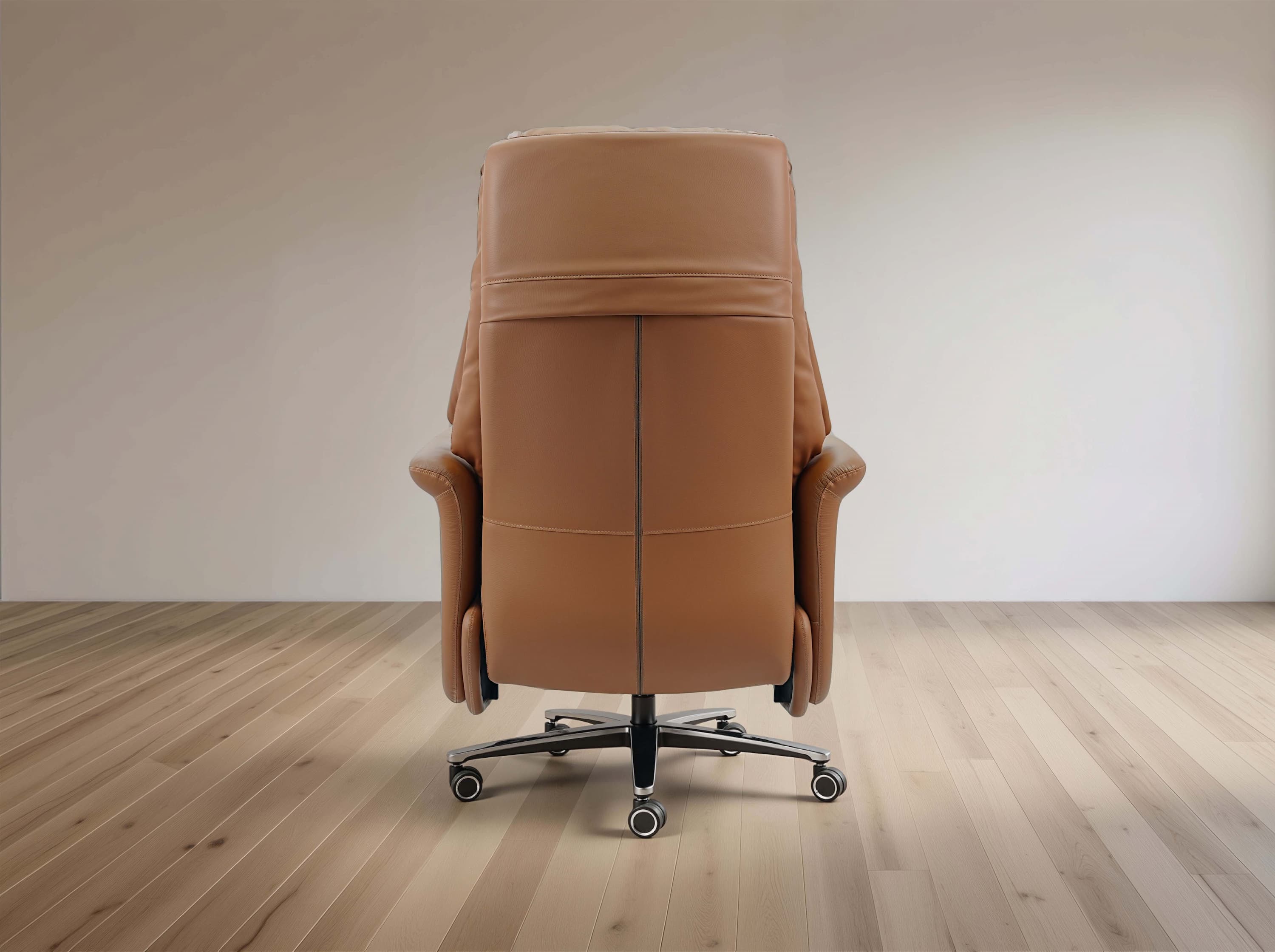 A tan leather office chair with a high back and five-star wheeled base, photographed from the rear in a minimalist room with light wood flooring and a neutral wall.