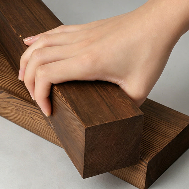 Hand holding a wooden block on a neutral background
