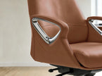 Close-up of a modern office chair upholstered in warm brown leather with polished chrome triangular armrest accents, shown in a clean indoor setting with light wood flooring and a neutral wall.