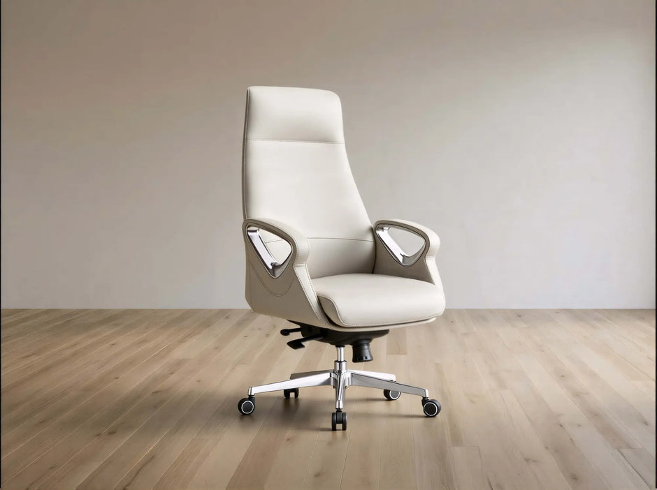A modern high-back office chair upholstered in light beige leather, featuring chrome armrests and a five-star wheeled base, set against a minimalist beige wall and light wood floor.