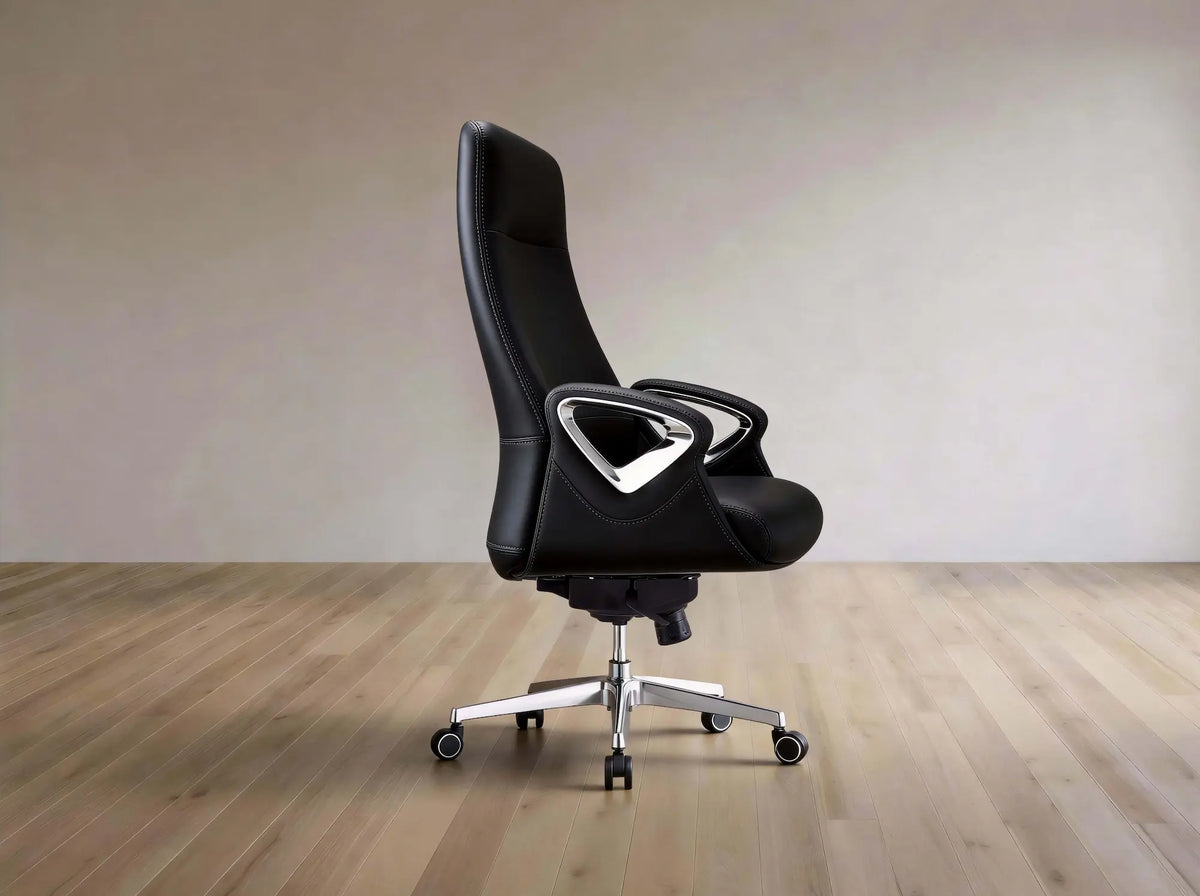 A modern black leather office chair with a high back, sculpted armrests, and a chrome five-star base, shown on a light wood floor against a neutral beige wall.