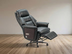 Black leather recliner chair with ottoman on a wooden floor.
