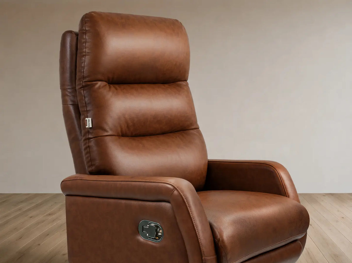 A brown leather recliner chair with a high backrest, shown in a studio setting with a neutral beige wall and light wood floor.