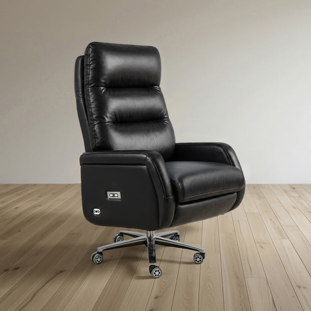 A black leather high-back recliner office chair with a power outlet on the side, mounted on a chrome five-star wheeled base, set against a minimalist beige wall and light wood floor.