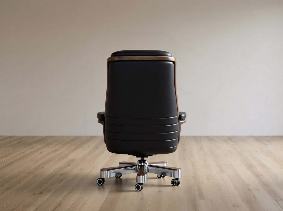 Black office chair on a wooden floor with a plain wall background